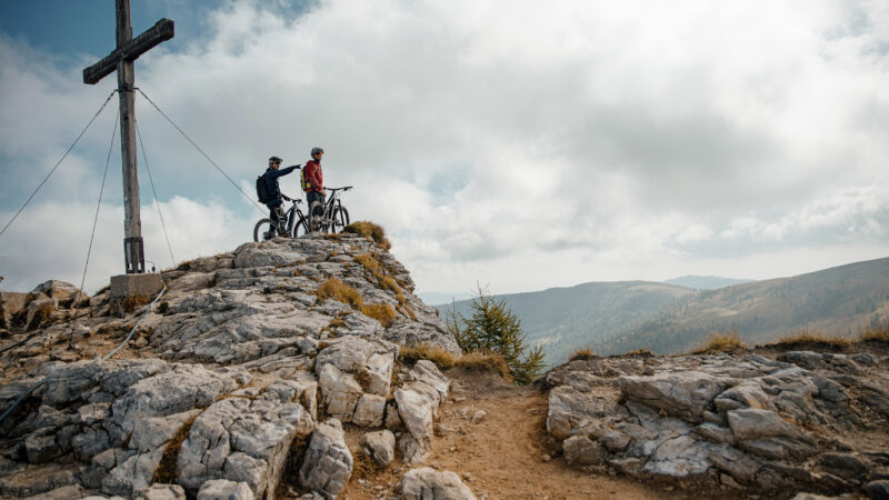 Mit dem Mountainbike am Gipfelkreuz der Nocky Mountains © Felix-Saller / desire lines